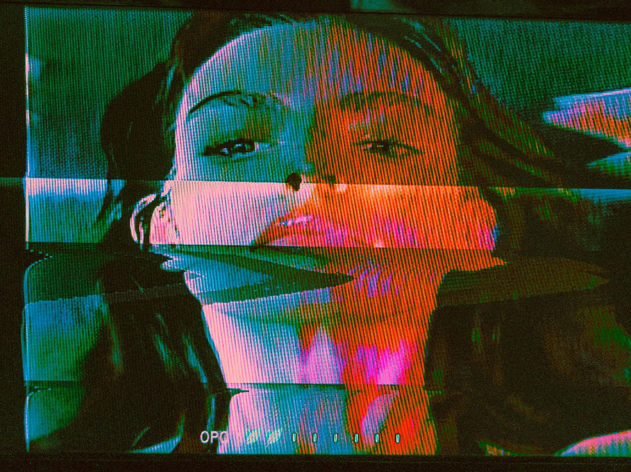 A face on a glitching television screen